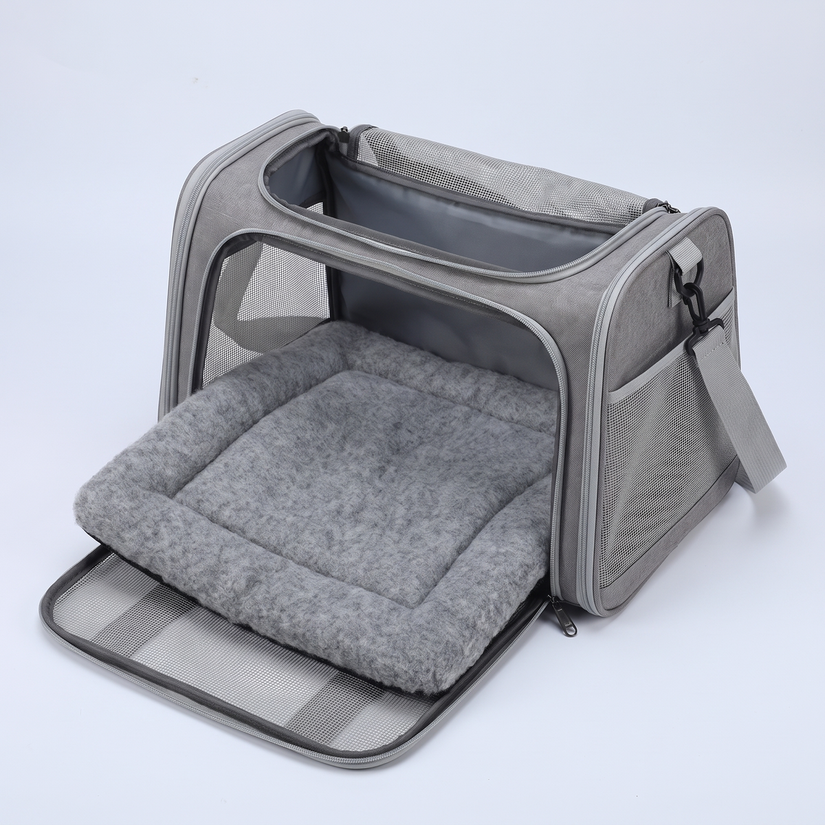 The carrier open from above with the padded wool base mat lifted out